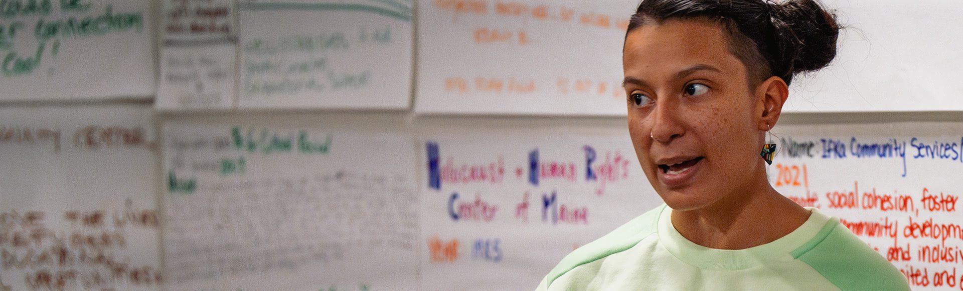 An instructor speaks to the class in front of a whiteboard.