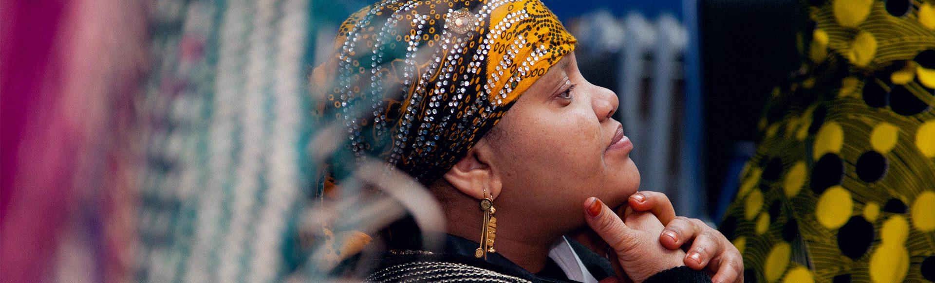 A woman listens intently to the speaker at an event
