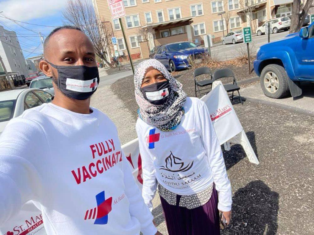 Two workers at AK Health and Social Services pose for the camera wearing masks on their faces