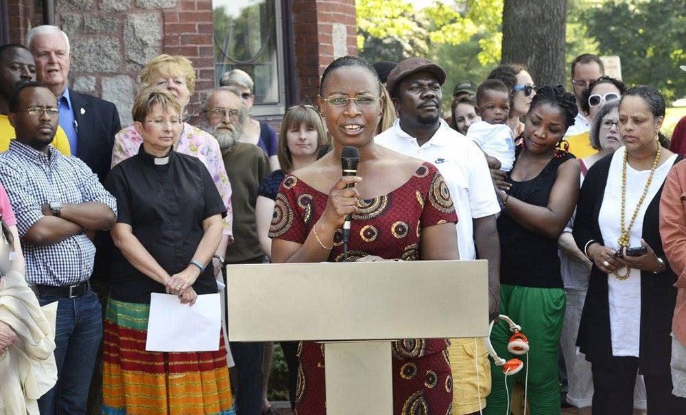 A Burundi woman speaks at a podium to an audience