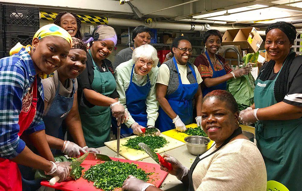 Many women work together with knives chopping herbs together