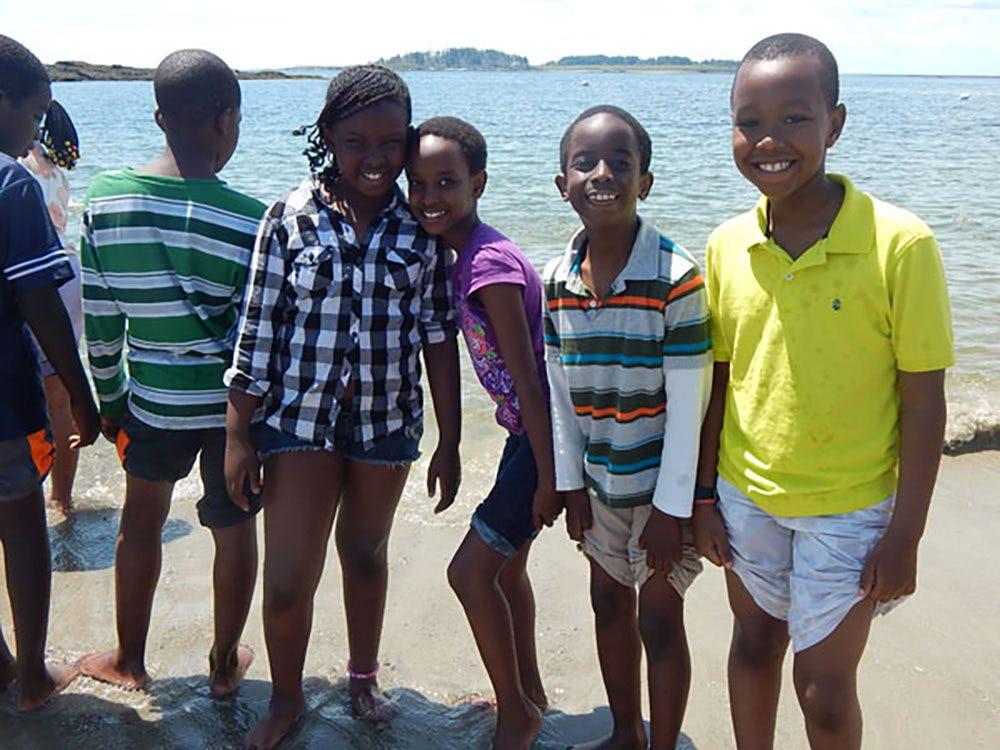 Intercultural Children laugh and smile by the Maine coast