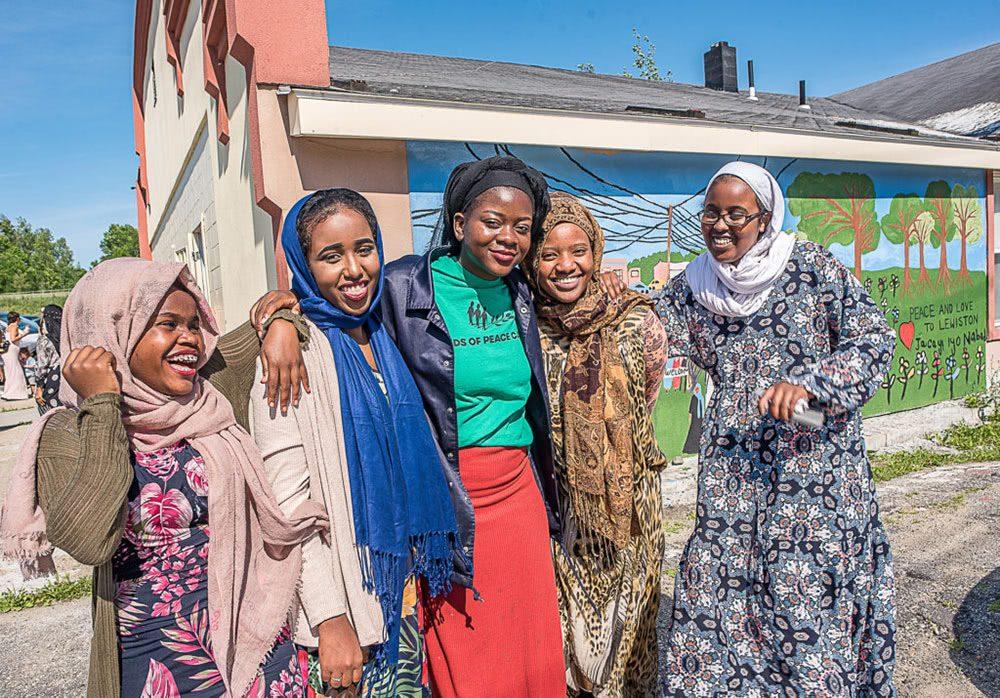 Young refugee women smile and hug