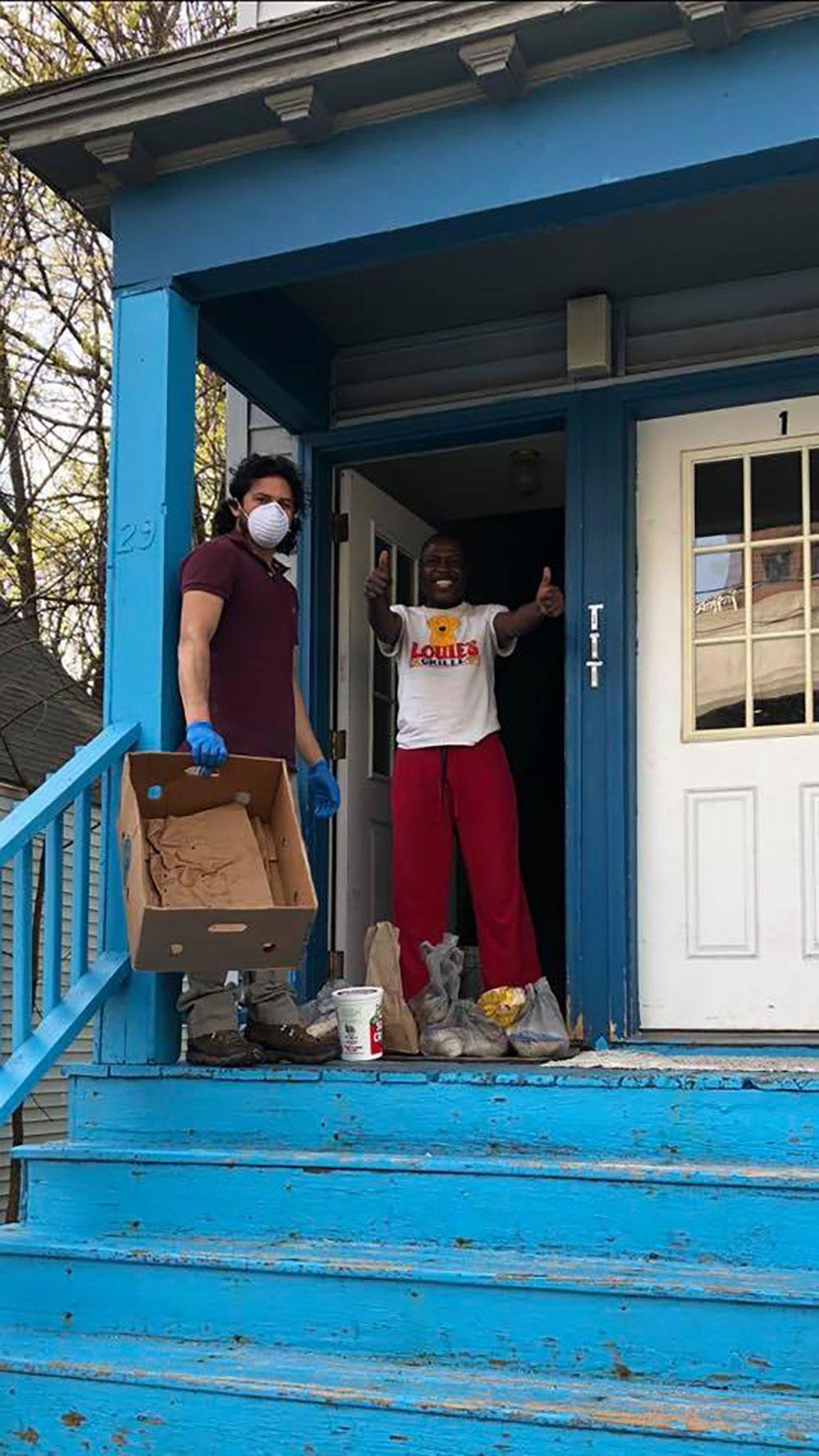 Volunteers clean out a house and smile at the front door