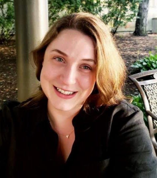 Joanna Robinson Clarke smiles at the camera while sitting on her patio